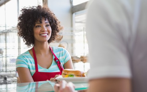 Girl serving sandwich at counter